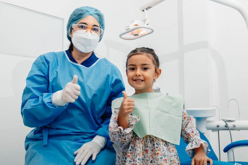 Child and dentist smiling after a successful dental checkup